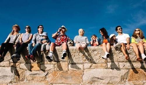 group of friends sitting on wall in st malo