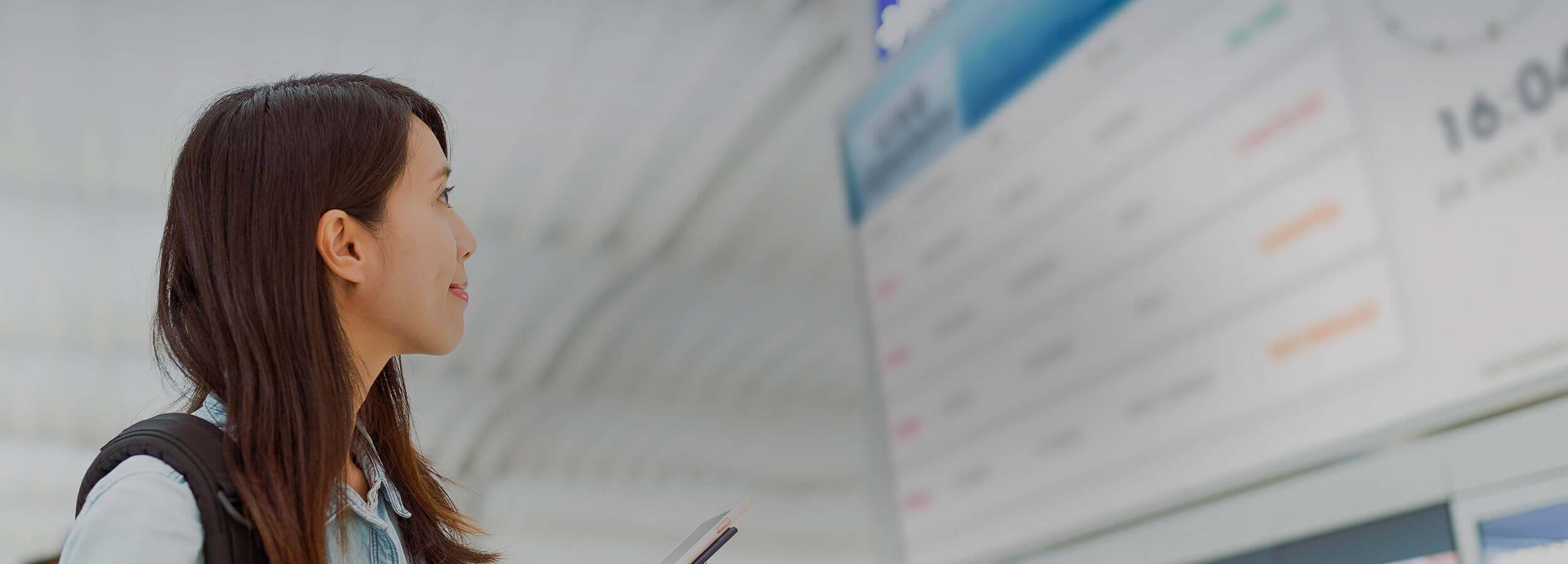 woman looking at a timetable on a screen