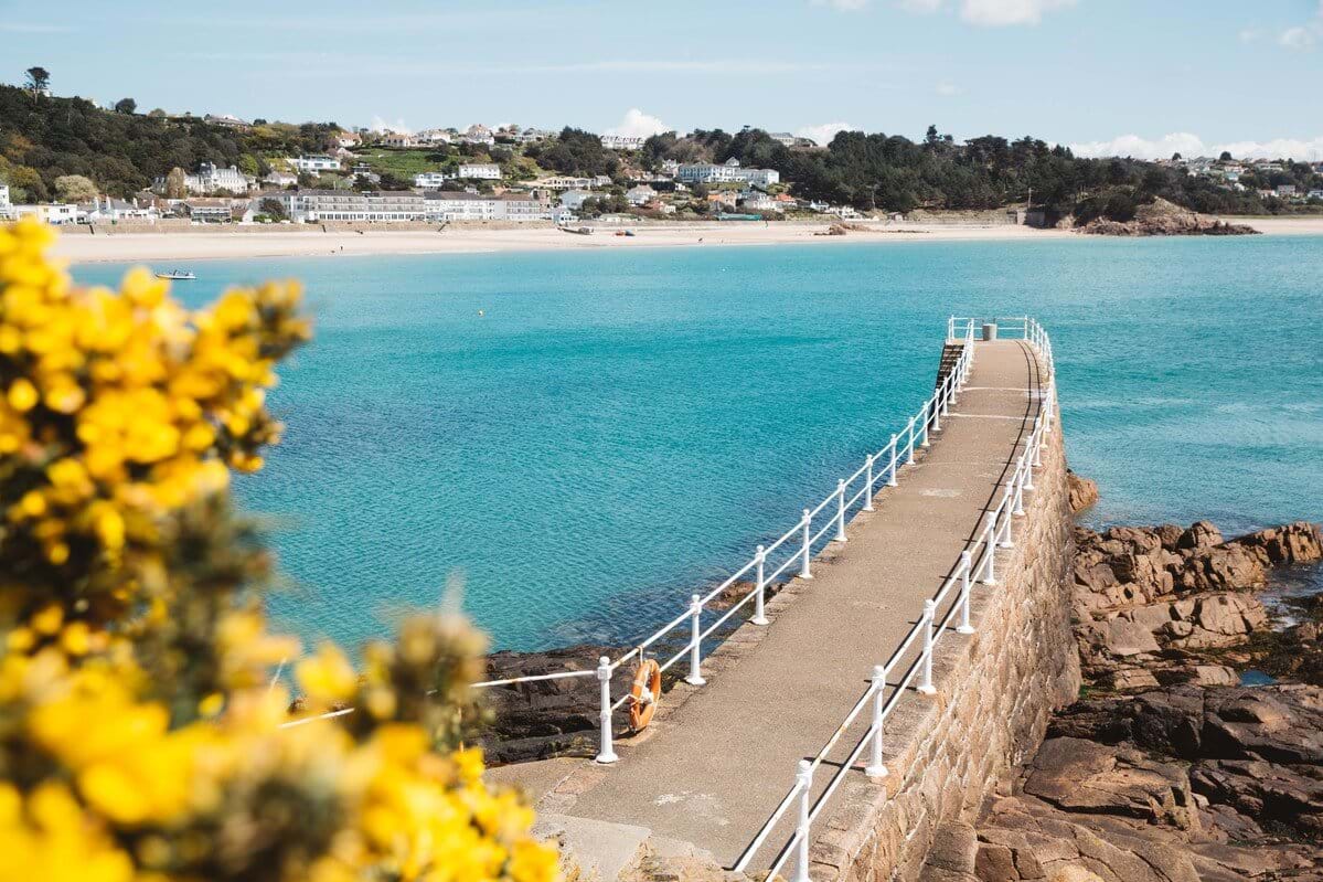Looking back to shore across a jetty with views over the sea to the beach